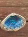 This is another view of the large clamshells that acts as the base of the bright blue ocean resin Beach Scene set inside the center of the shell.  There are white waves at the sandy shore line area as well as tiny shells and Gemstones.  This shell says Love You in the center of the blue resin with white and black letter beads and is 1 shell in this set of 2.