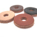 Close-up of 4 round leather washers in 4 different colors on a white background