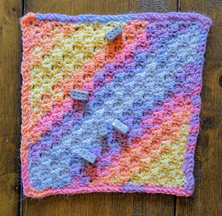 Photograph of the altar cloth with a set of blue knucklebone dice strewn across it.