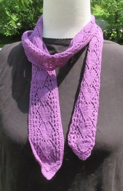 a narrow purple long scarf with an arrow-like motif wrapped around the neck of a dress form