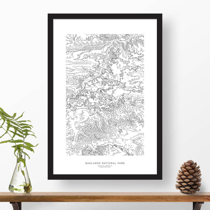 National park print of Badlands National Park with black and white topography in a black 24x36 vertical frame.