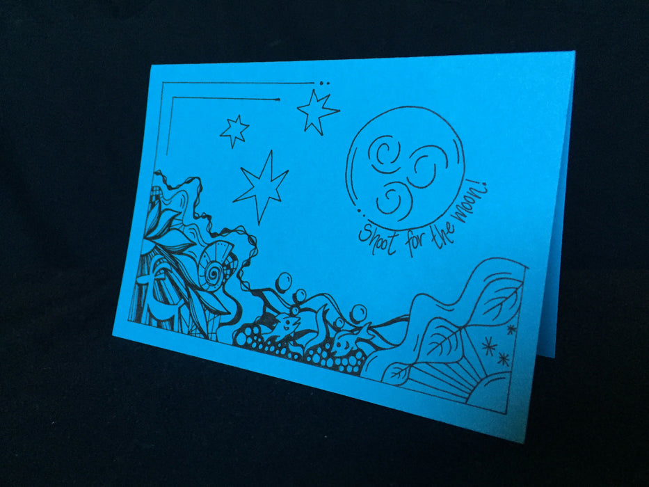 Card features an abstract nature scene including a goat, fish, and a night sky along with the words shoot for the moon.