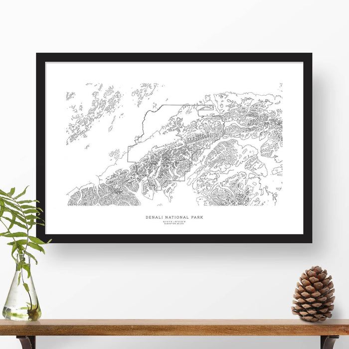 Map wall decor in a black frame. Contour lines of Denali National Park are drawn on a white background. Text  below the map can be customized to create custom adventure art.