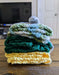 Photograph of the kitchen towels folded up, stacked on top of each other, and tied together.