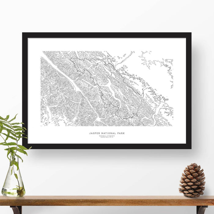 Map wall decor in a black frame. Contour lines of Jasper National Park are drawn on a white background. Text  below the map can be customized to create custom adventure art.