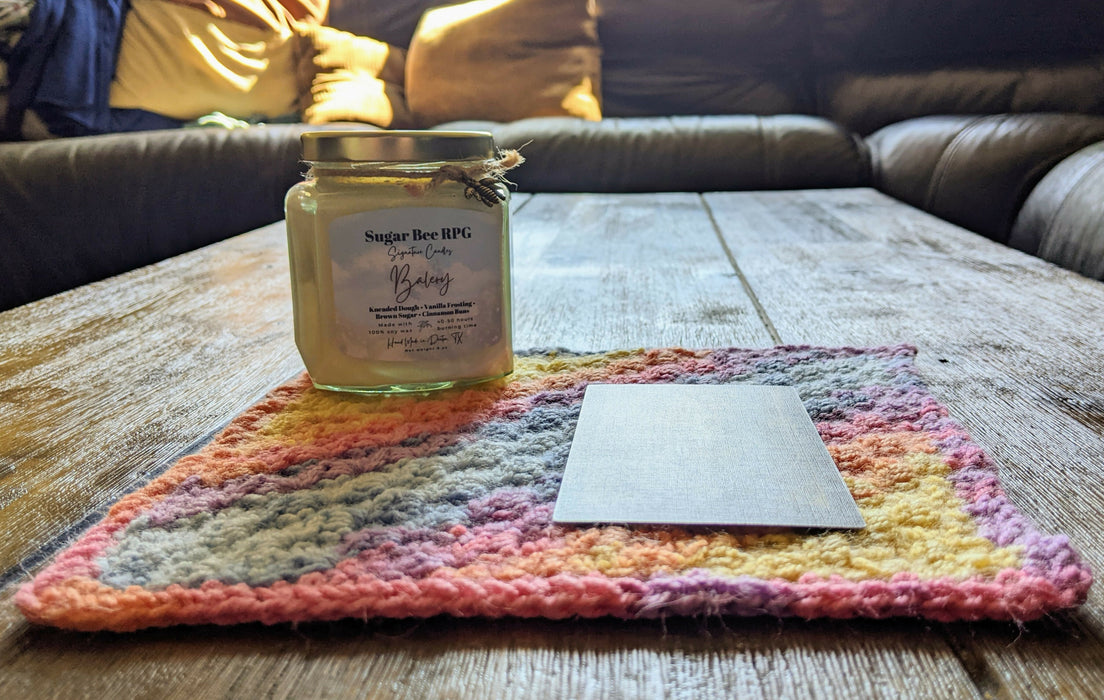Photograph of the altar cloth with the candle and tarot card on it, taken from a different angle.