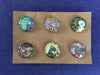Set of 6 individually handmade decorative magnets measuring one inch in diameter, made with glass cabochons and paper scraps.  Magnet 1: Use it up, wear it out, make do, or do without Magnet 2: Save the bees Magnet 3: We are of the Earth and from the stars Magnet 4: Nature not Wifi Magnet 5: Rectify Magnet 6: Boldly going nowhere