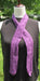 a narrow purple long scarf with an arrow-like motif on a dress form