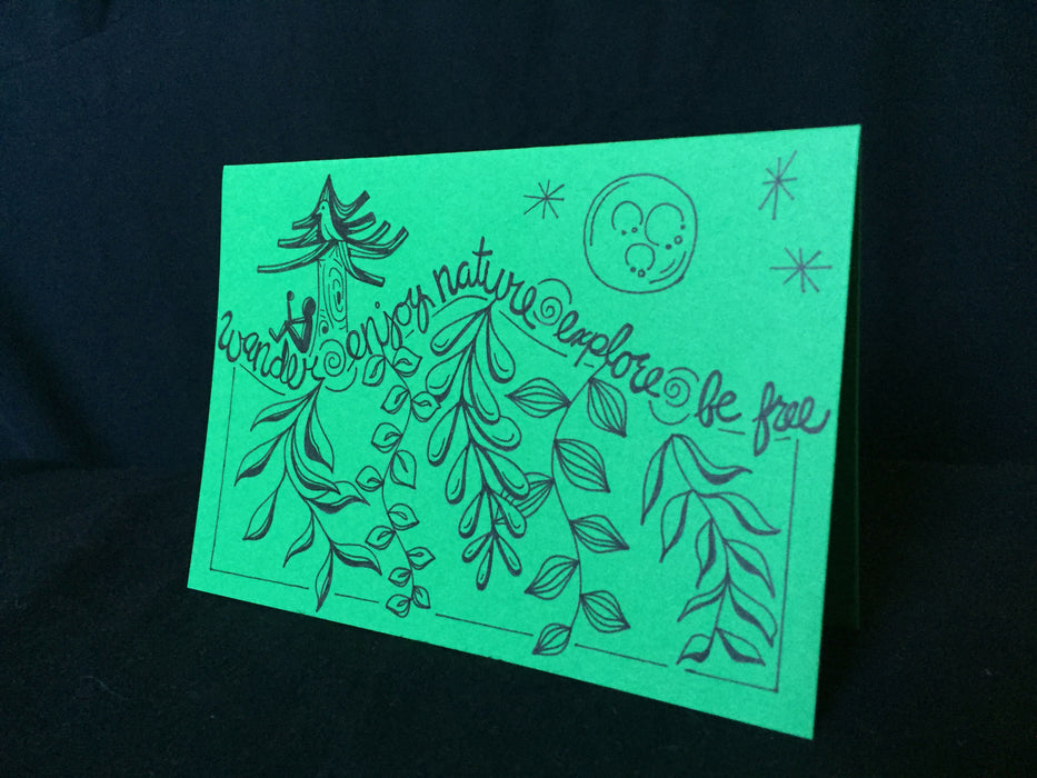 Card features stylized words wander, enjoy nature, explore, be free, along with a nature scene of a person under a tree in the evening.