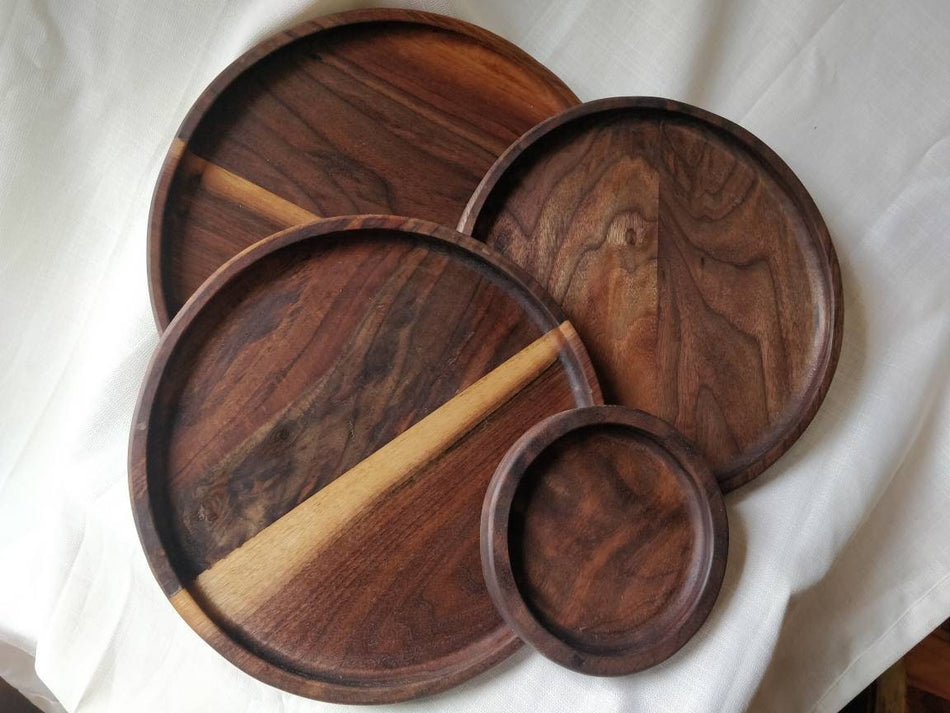 Four handmade wooden plates of varying sizes.