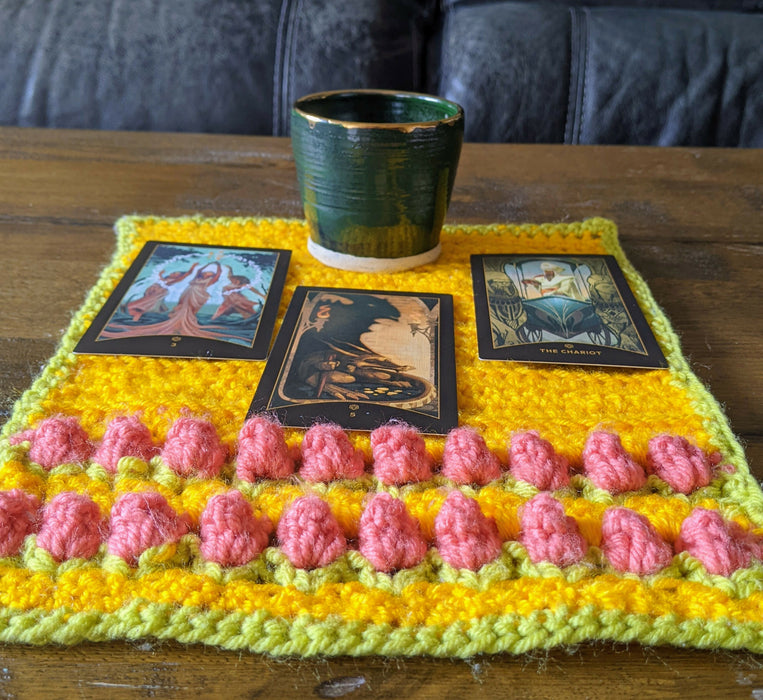 Photograph of the altar cloth with the tarot cards and cup on it, taken from a different angle.