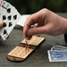 Two people playing on a small, foldable, wood and leather travel cribbage board
