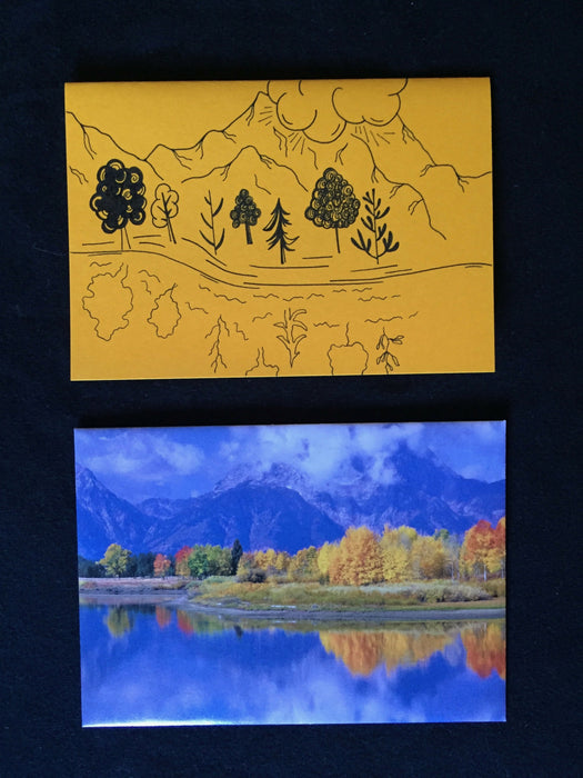 Envelope features photograph mountains and trees over water in vibrant blue and yellow colors. Card features an abstracted reflection of envelope image on yellow paper.