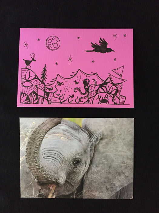 Card features an evening nature scene including a goat, octopus, crab, crow, and fish on lilac-colored paper. Envelope features close-up photograph of a juvenile elephant.
