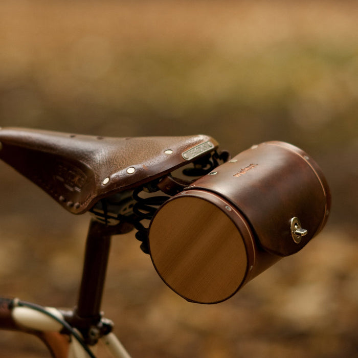 Dark brown leather barrel bicycle bag mounted on Brooks bike seat
