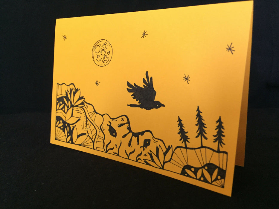 Card features an evening nature scene with a crow and fish on gold-colored paper.