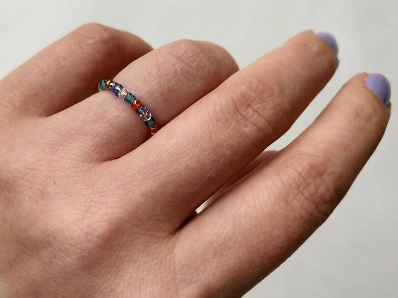 A beaded ring on a woman's hand.