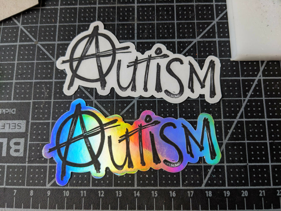 clear and holographic stickers that read 'autism' with the A in the anarchy A style