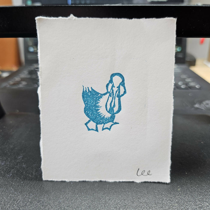 a print in blue ink of a little duck looking up at the camera